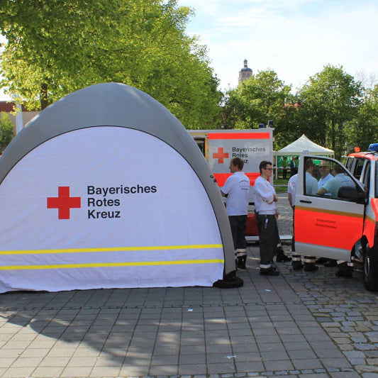 Schnelleinsatzzelt Gybe Humanity Tent Emergency im Einsatz / BRK Logo